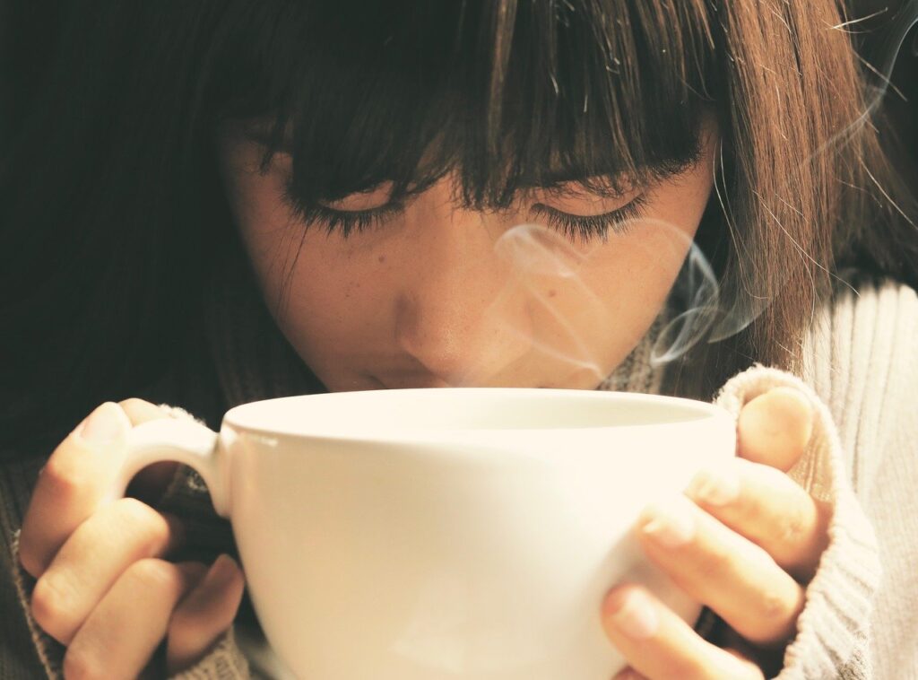 女性がコーヒーを飲んでいる画像