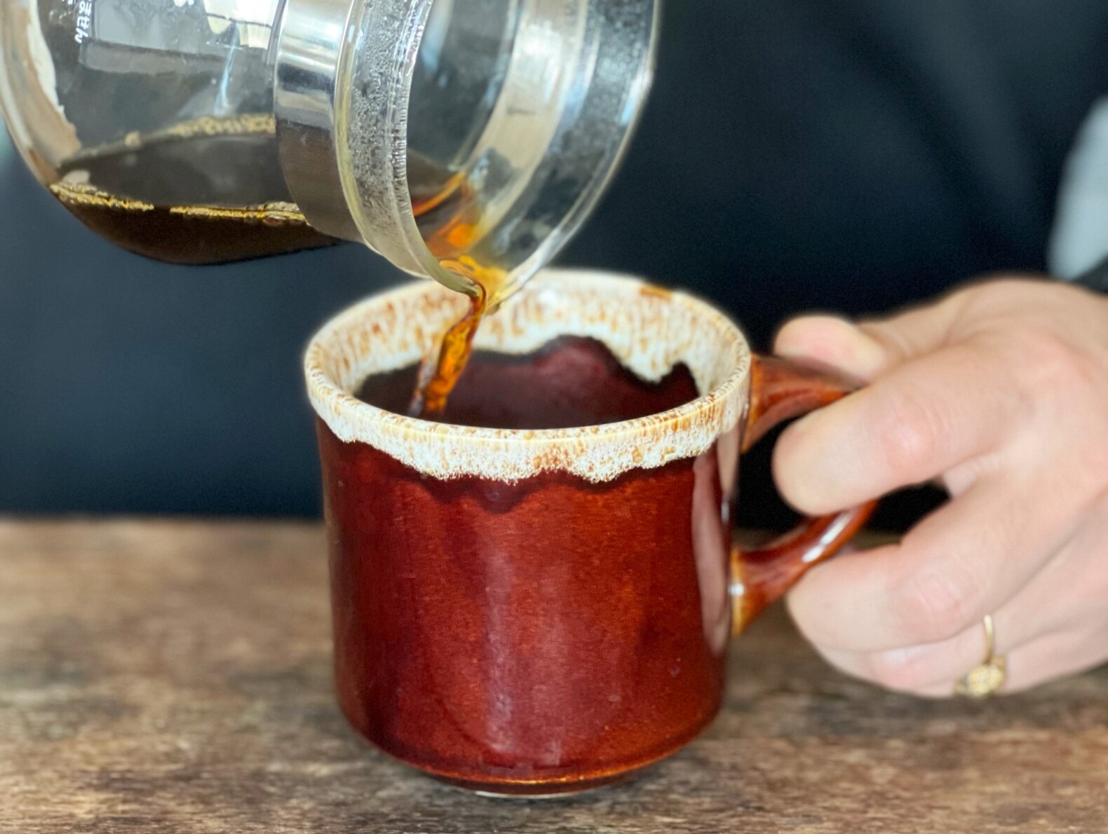 コーヒーをマグカップに注いでいる画像