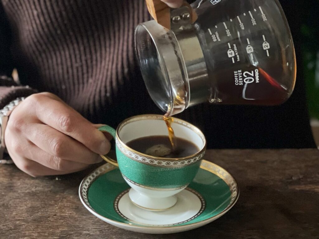 コーヒーカップにコーヒーを注いでいる画像